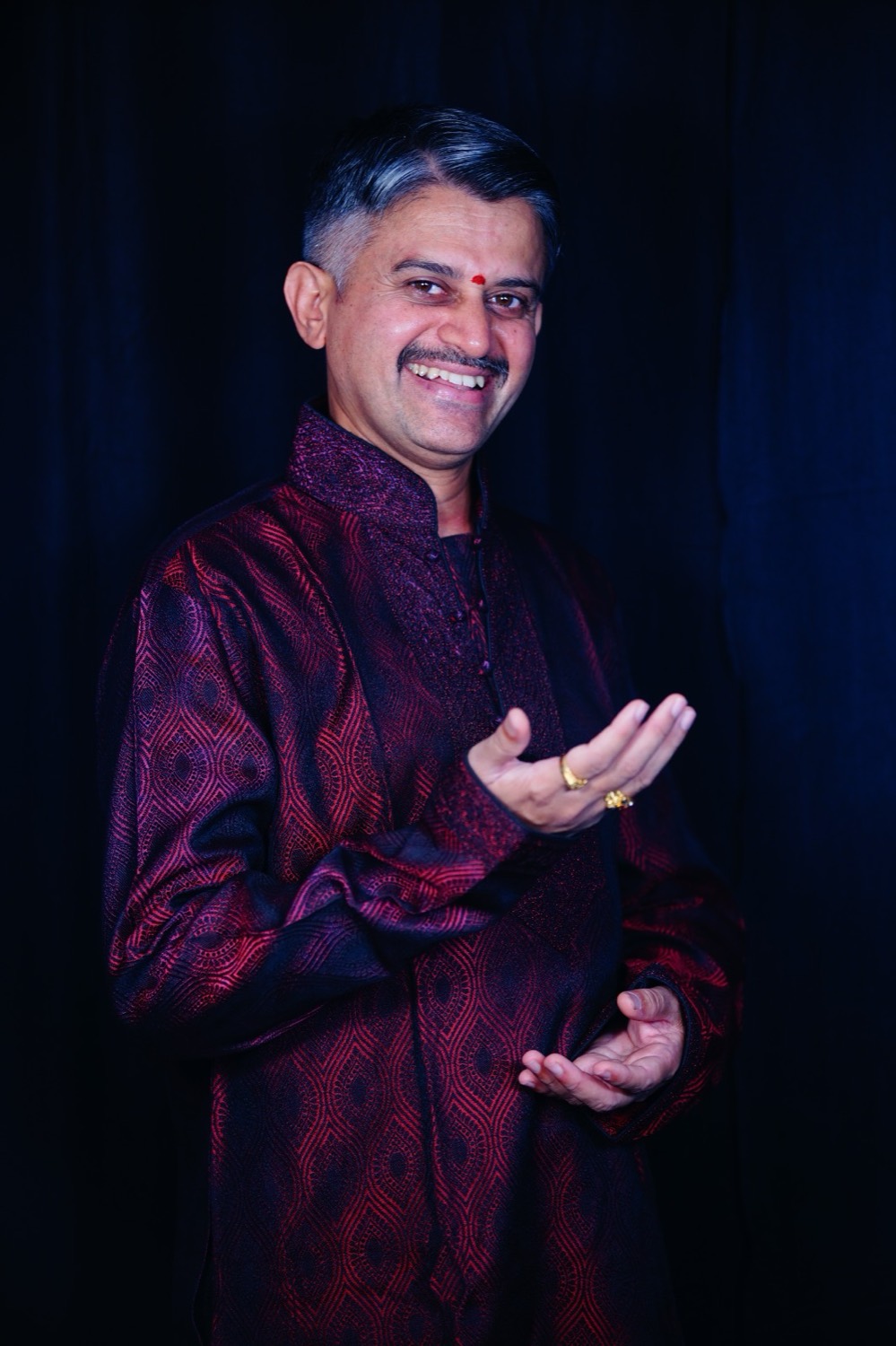 Vidwan M. S. Naveen singing, hands raised in a gesture