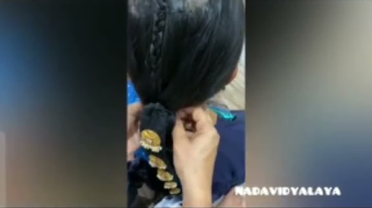 Vidushi Mithra Naveen setting a student's hair for Bharatanatyam